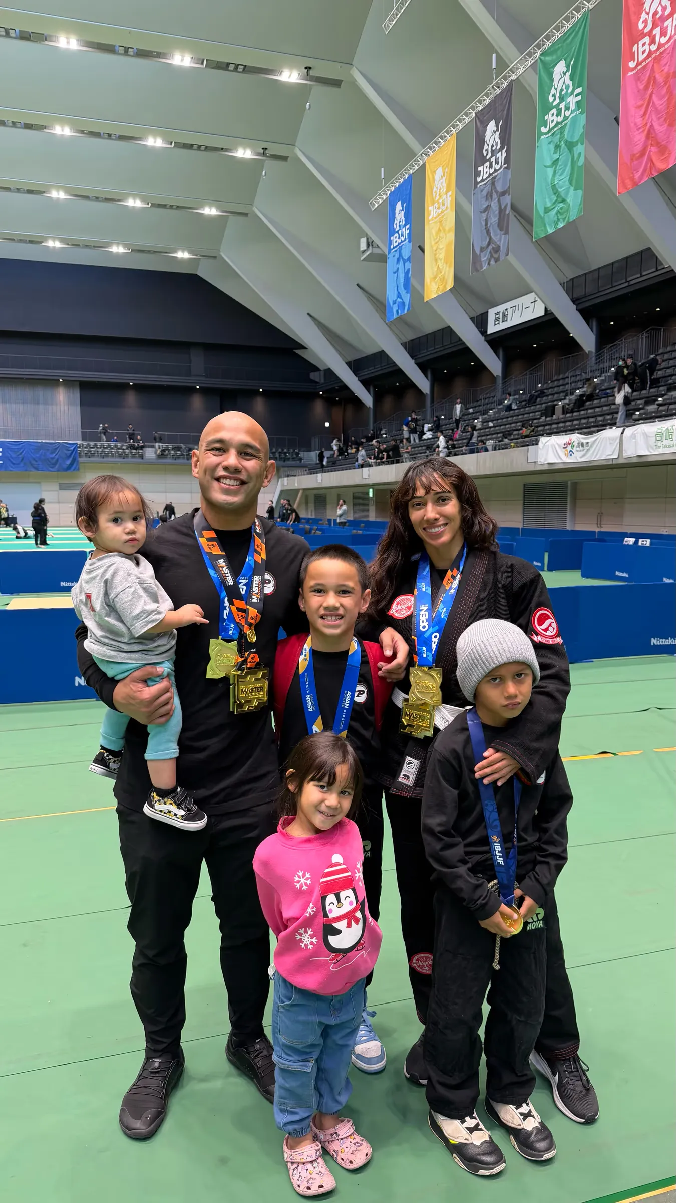 Frank Camacho with his wife and four children, all wearing competition medals